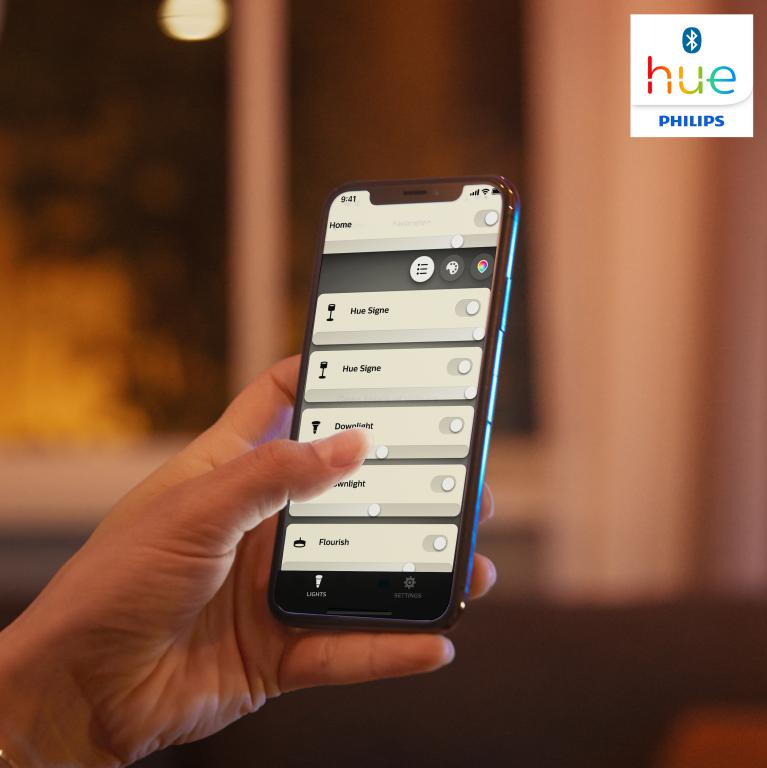 Mano sosteniendo un smartphone que muestra la aplicación Philips Hue, mostrando la configuración de la luz.