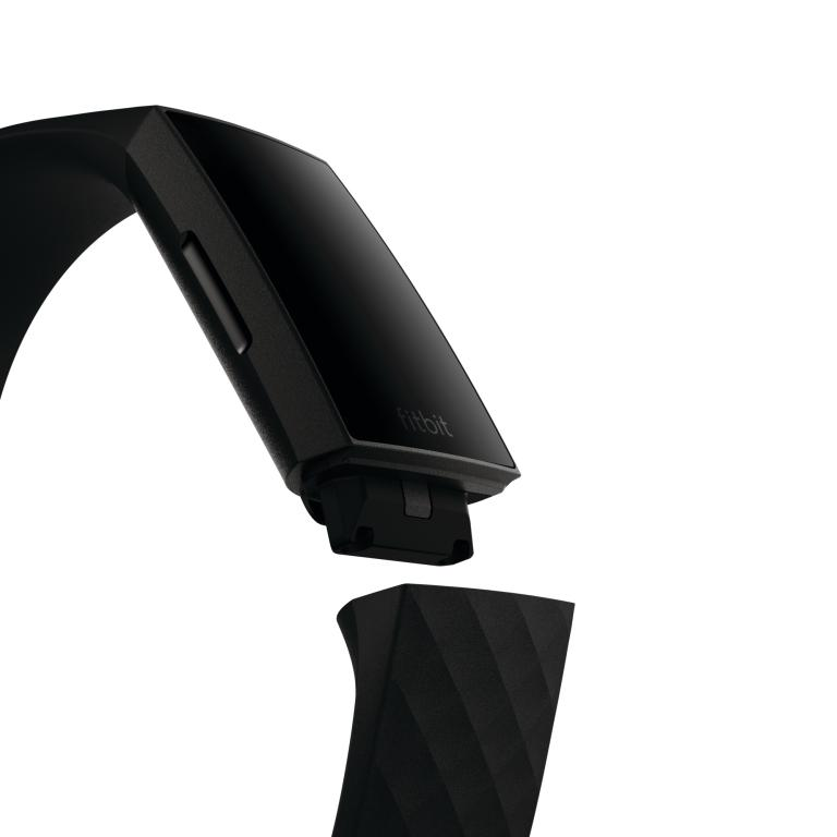 Rastreador de ejercicios negro con banda separada. 'fitbit' está escrito en el dispositivo, contra fondo blanco.
