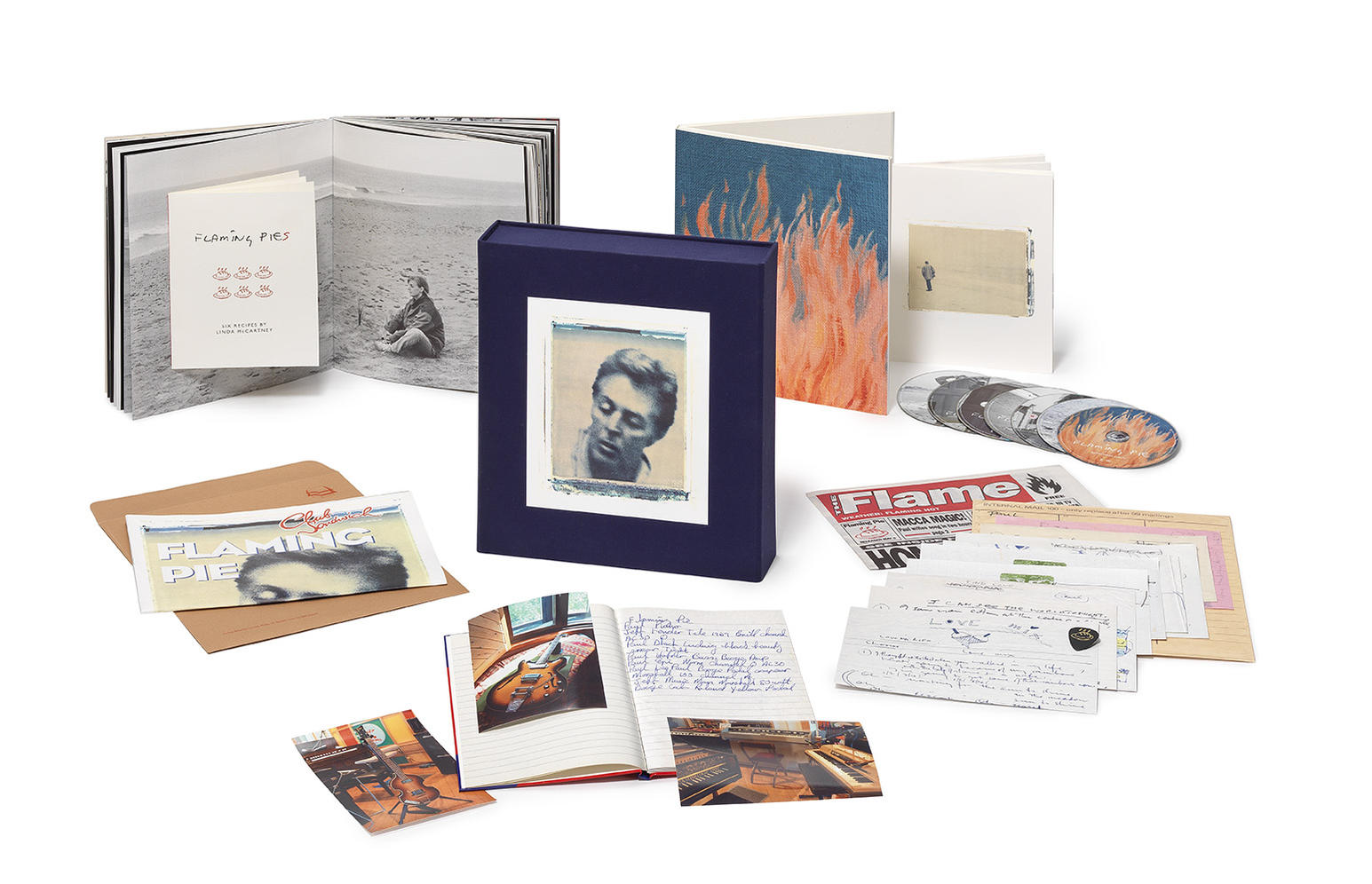 A collection of items, including books, photographs, and CDs, on a white surface.