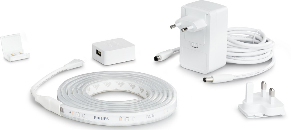 White Philips Hue lighting kit components. LED strip, power supply, and various connectors.