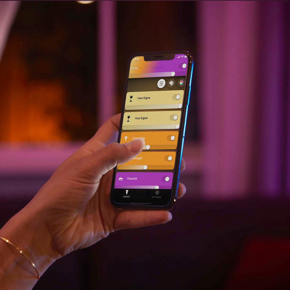A hand holding a phone displaying a digital interface.