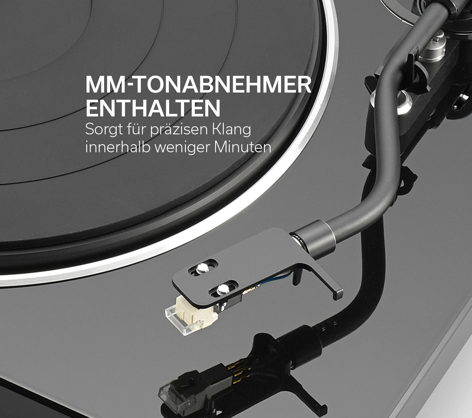Ein Plattenspieler mit schwarzer Oberfläche, Tonarm und Text: MM-TONABNEHMER ENTHALTEN.