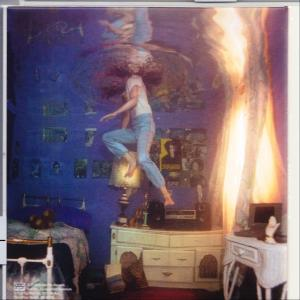 Person schwebt in einem Raum. Poster an der Wand, Tisch mit Lampe. Blaues und orangefarbenes Licht.