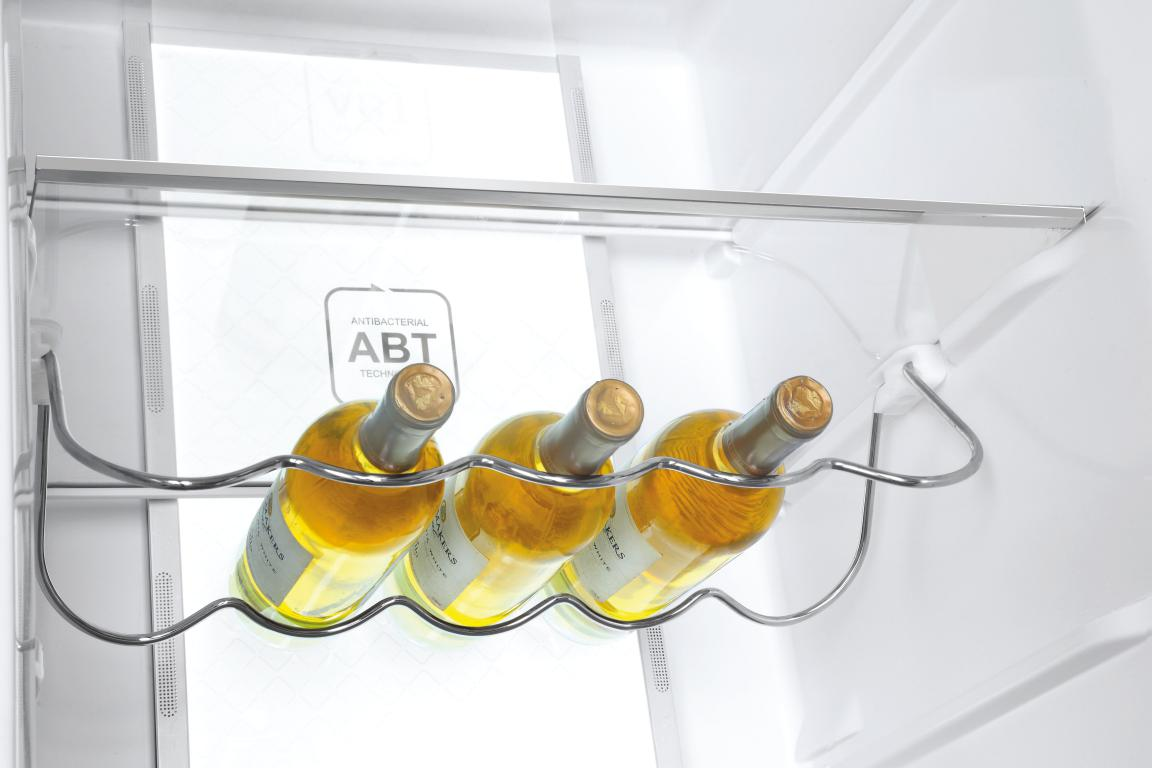 Botellas de vino en un refrigerador con botellas en un estante.