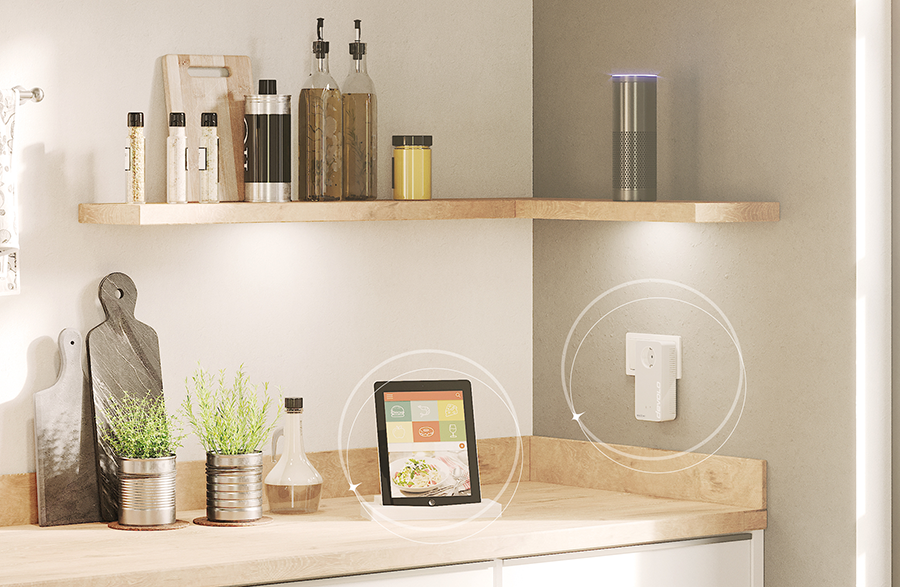 Kitchen scene with smart devices, a tablet, and smart speaker on a shelf.