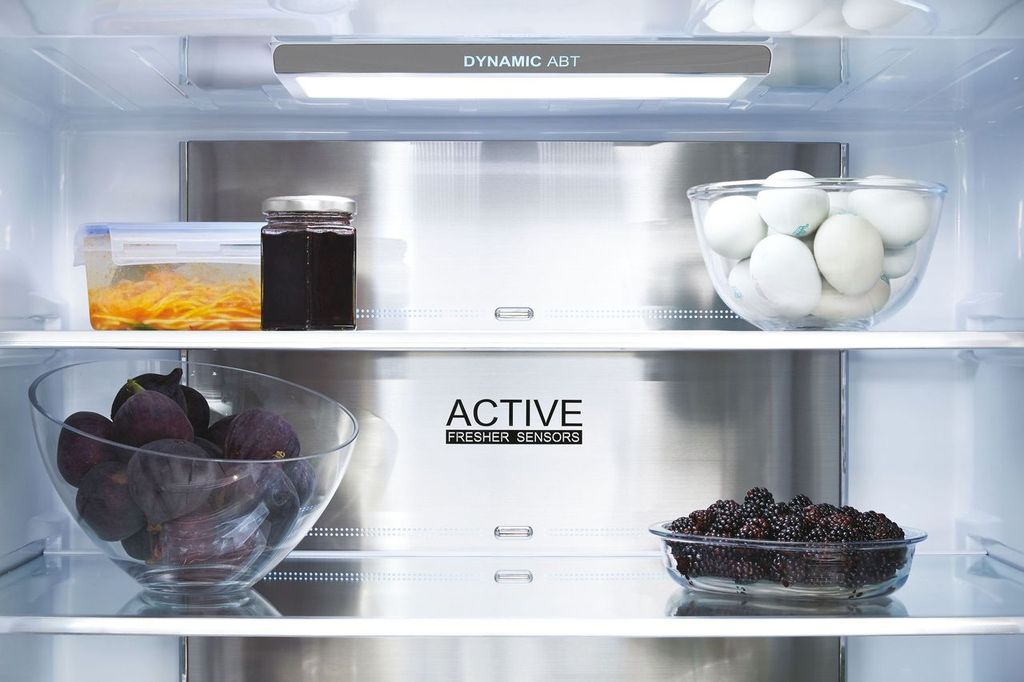 Interior de refrigerador con estantes. Incluye un tarro, un recipiente, huevos, higos y moras.