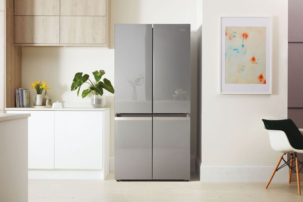 Un refrigerador gris moderno con cuatro puertas en una cocina luminosa.