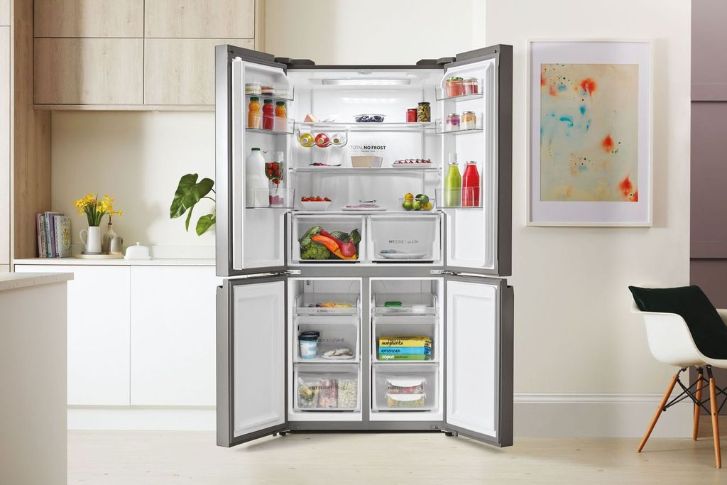 Refrigerador abierto con varios alimentos dentro, con un fondo de cocina brillante.