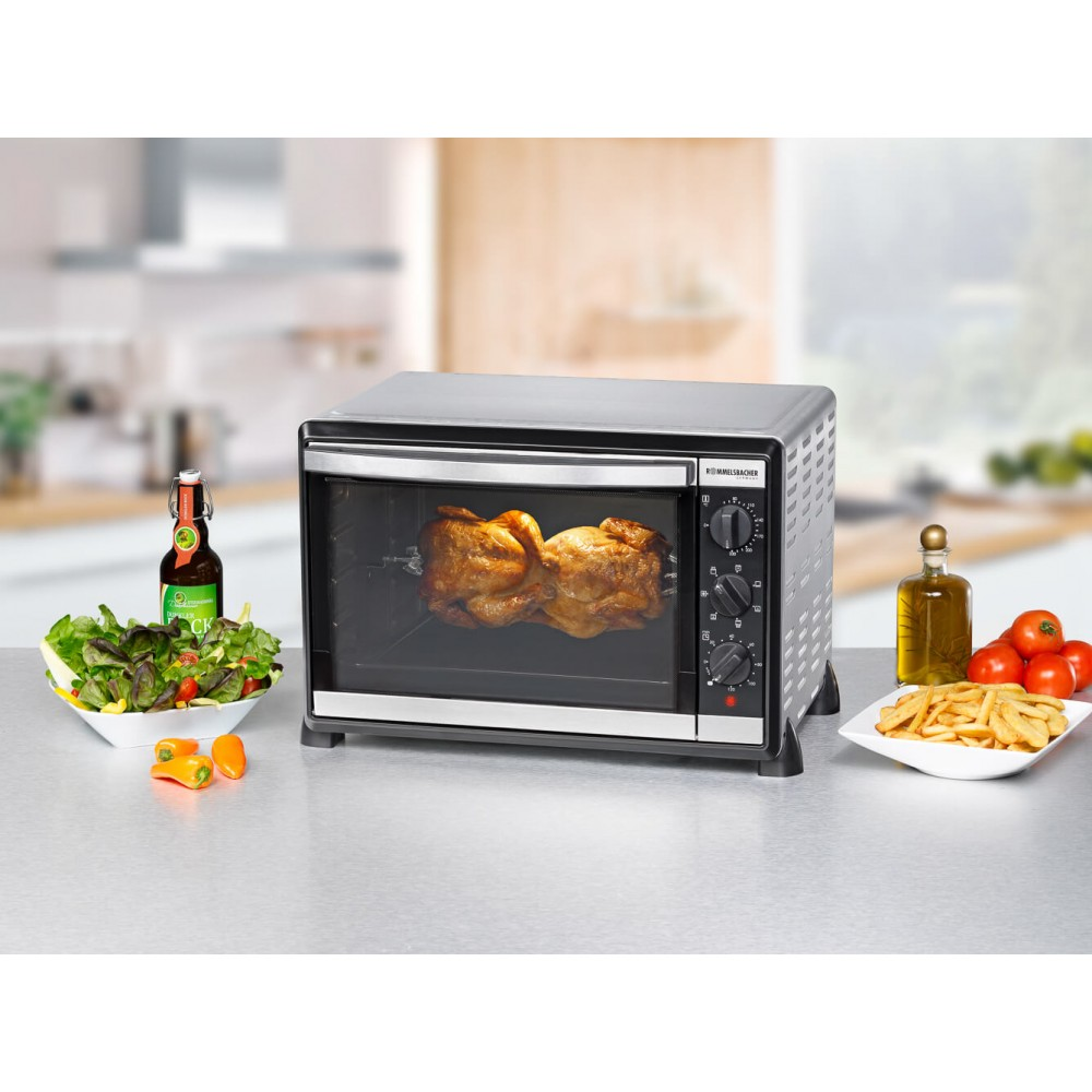 Rotisserie-Ofen mit gebratenem Hähnchen, Beilagen und Bierflasche.