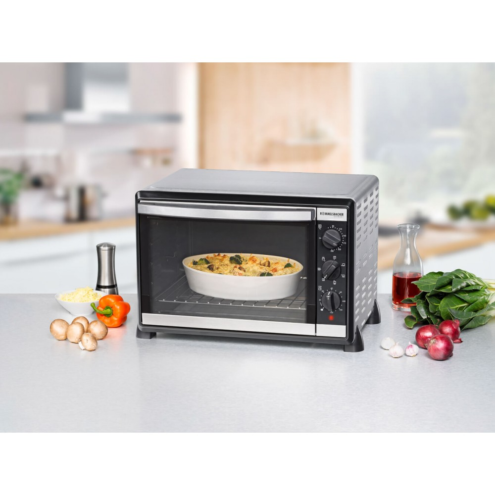 Schwarzer Ofen mit Essen darin. Gemüse und Auflauf in einer weißen Schüssel.