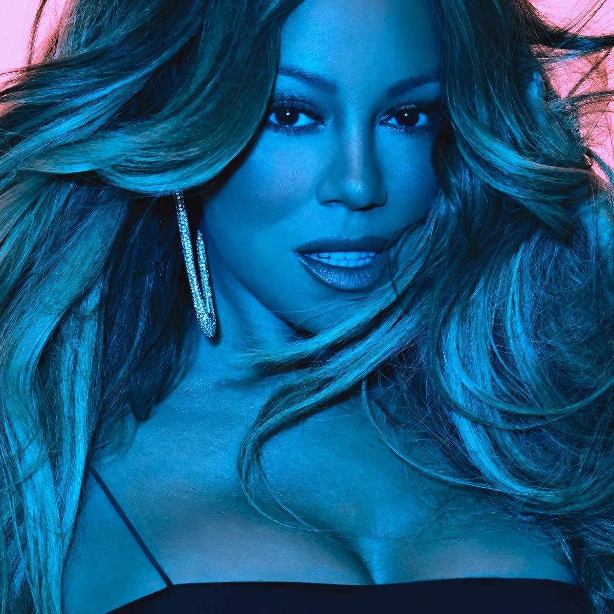 Mariah Carey arca, a kamerába nézve, kék és rózsaszín tónusok, fülbevalót viselve.