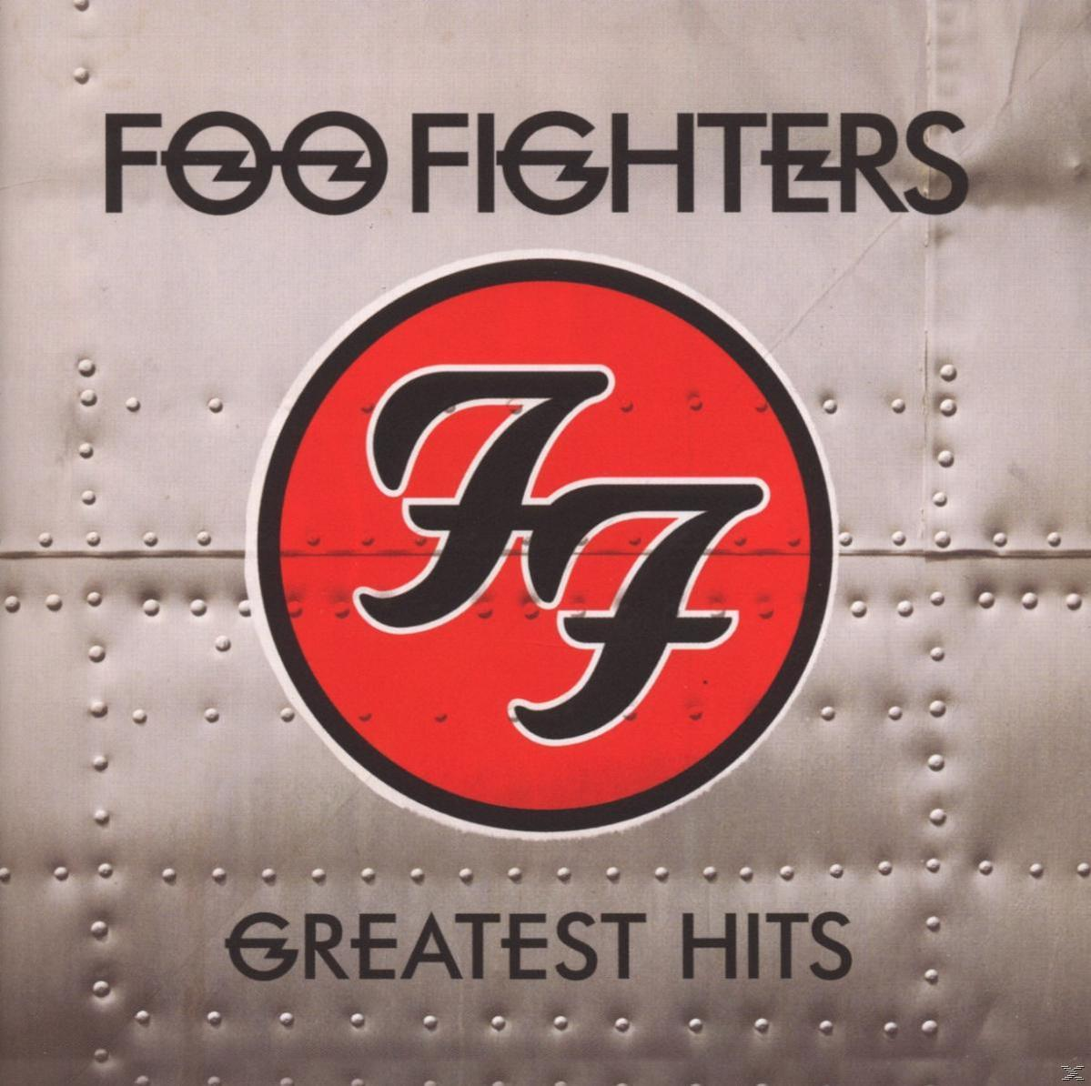 Albumcover für Foo Fighters „Greatest Hits“ mit einem roten Kreis mit dem Logo der Band auf silbernem Hintergrund.