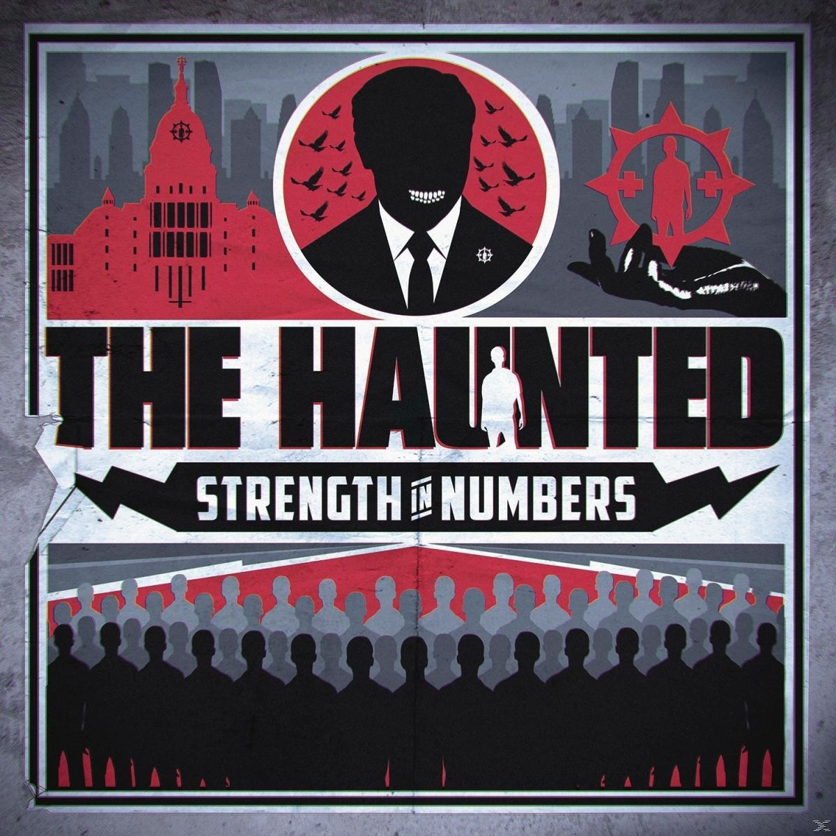 Poszter "The Haunted" és "Strength in Numbers" felirattal. Férfi sziluett, madarak, épületek, tömeg.