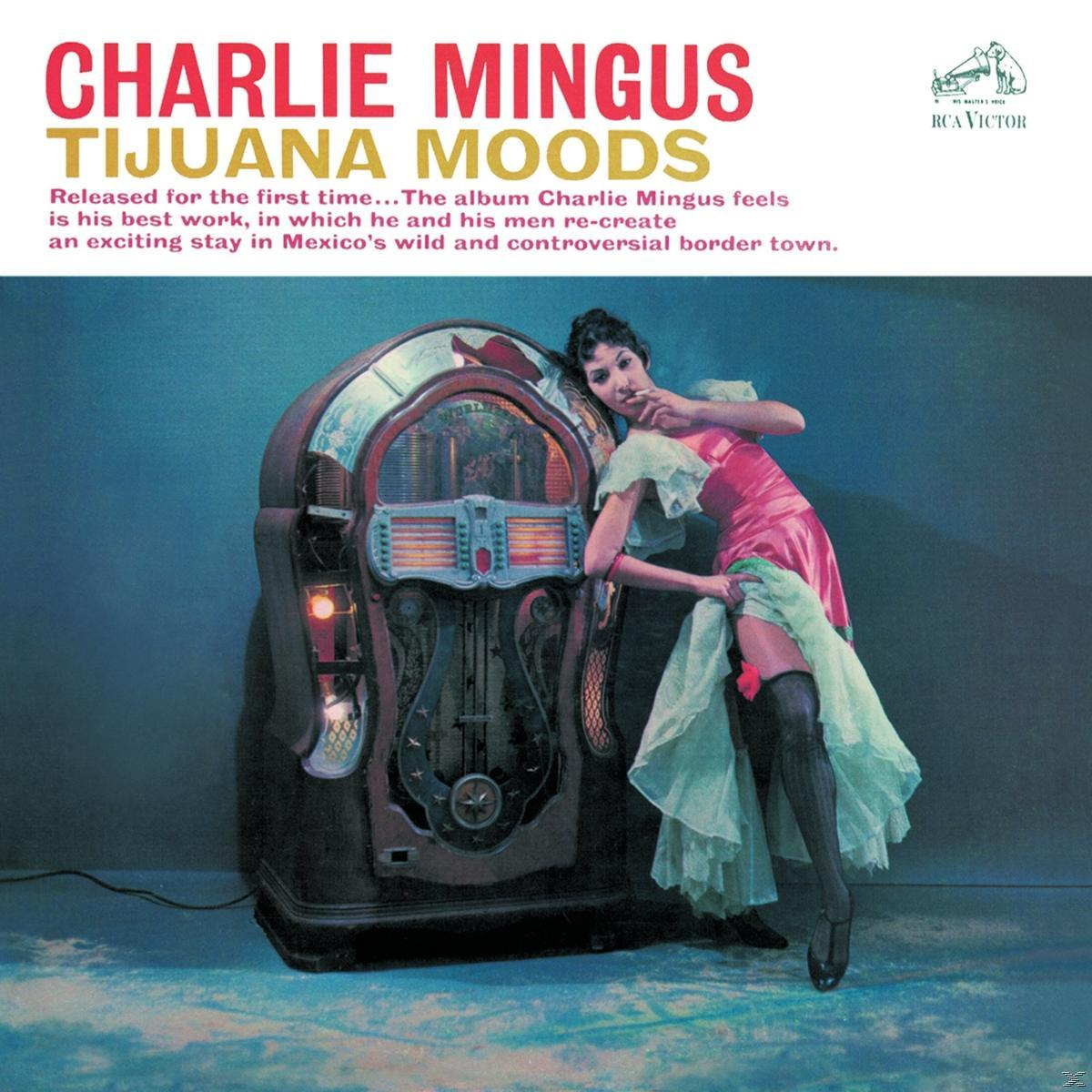Frau in rosa Kleid mit Jukebox. Albumcover mit dem Titel Charlie Mingus und Tijuana Moods.