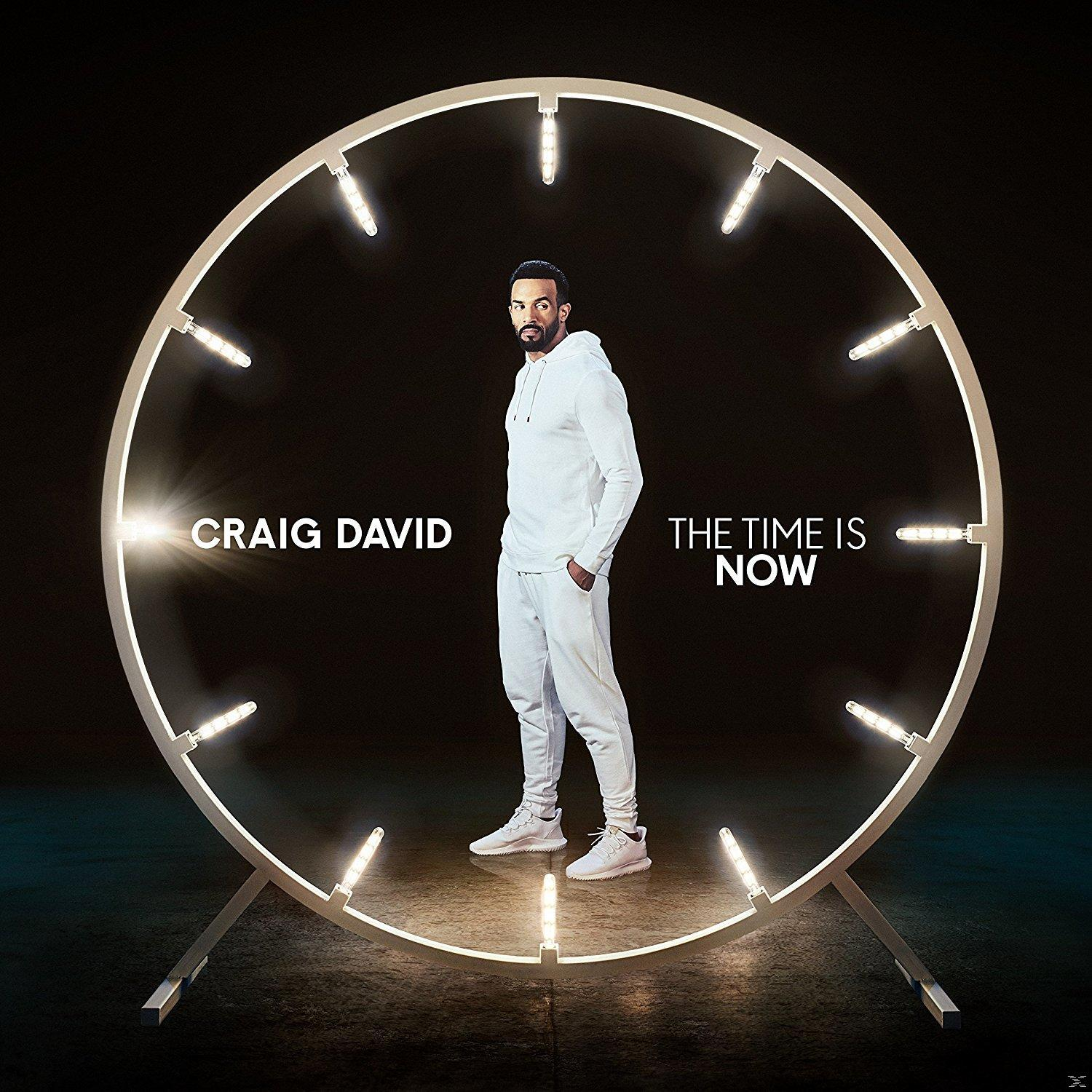 Craig David fehér öltönyben egy óra alakú keretben áll, világítással. A szöveg: "THE TIME IS NOW".