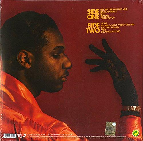 Albumcover mit einem Mann in einem orangefarbenen Hemd, der nach unten schaut. Eine Hand ist sichtbar.