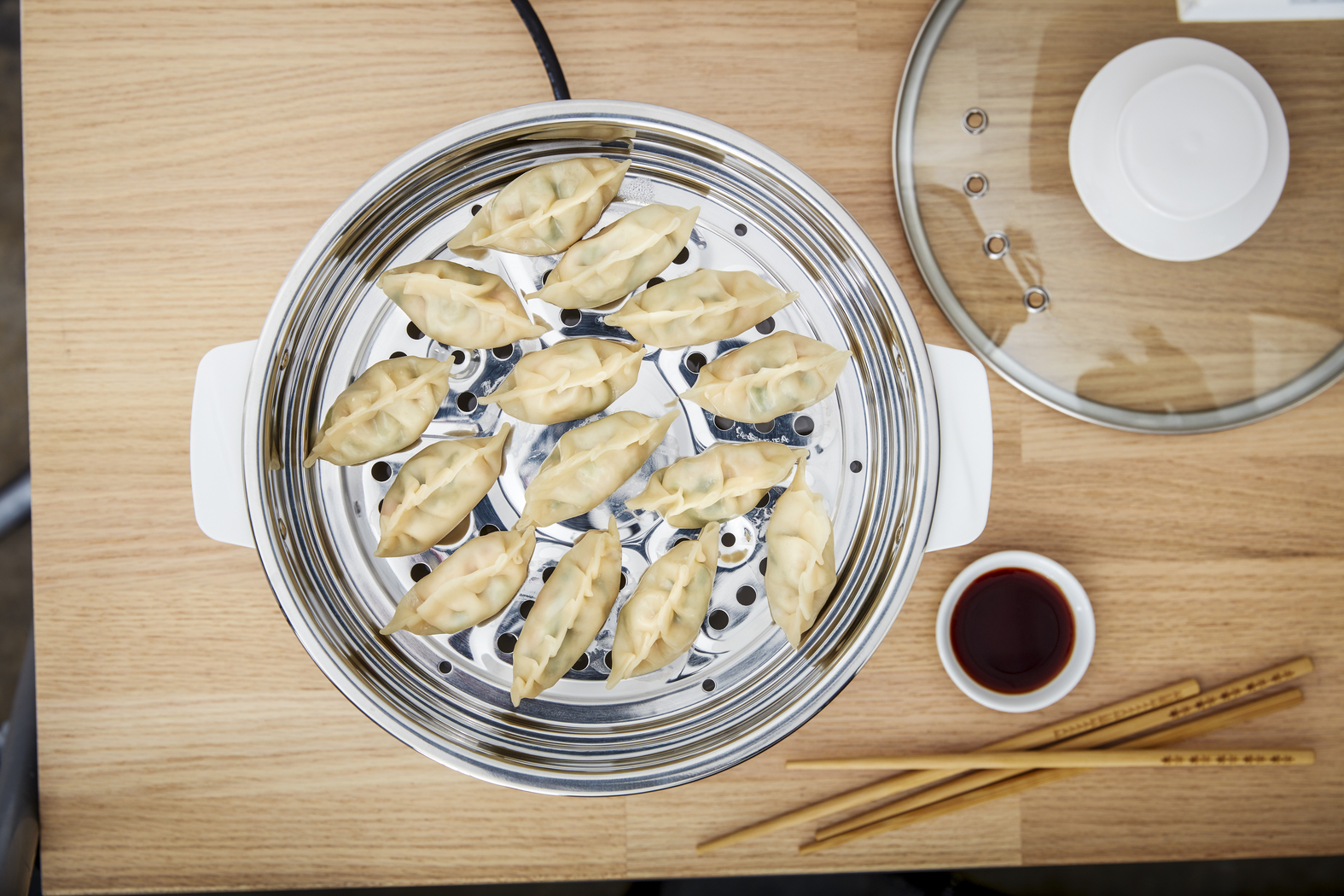 Stomer met dumplings, sojasaus en eetstokjes.