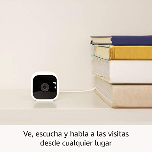 Una cámara de seguridad blanca junto a una pila de libros, con texto en español abajo.