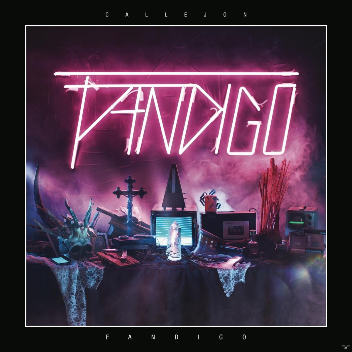 Albumcover: Neon-Schild 'FANDIGO' über einer dunklen Szene mit Objekten, einem Kreuz und einem Schädel.