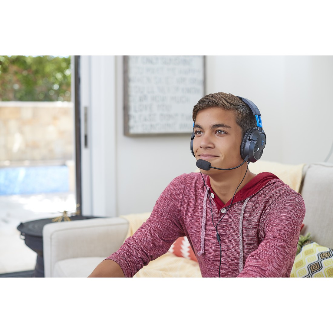 Ein junger Mann mit Headset lächelt, während er etwas ansieht.