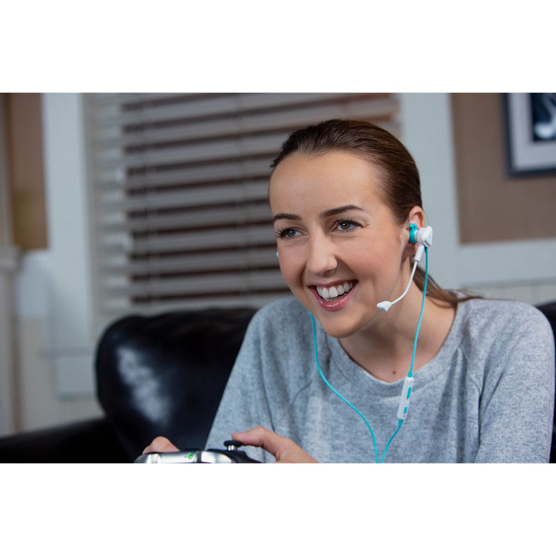 Eine Frau spielt mit Controller und Headset und lächelt.
