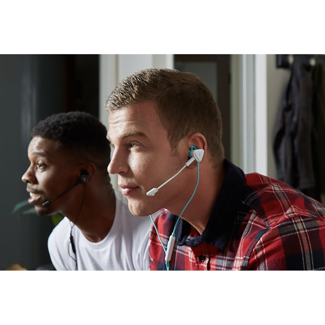 Zwei Männer mit Headsets, die sich auf einen Gaming-Bildschirm konzentrieren.