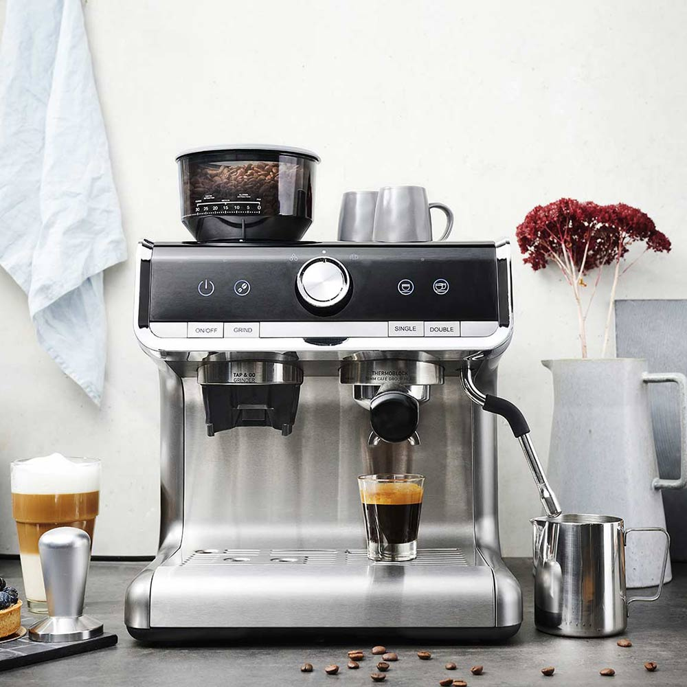 Espressomaschine mit Kaffeetassen und einer Mühle. Ein Schuss wird zubereitet.
