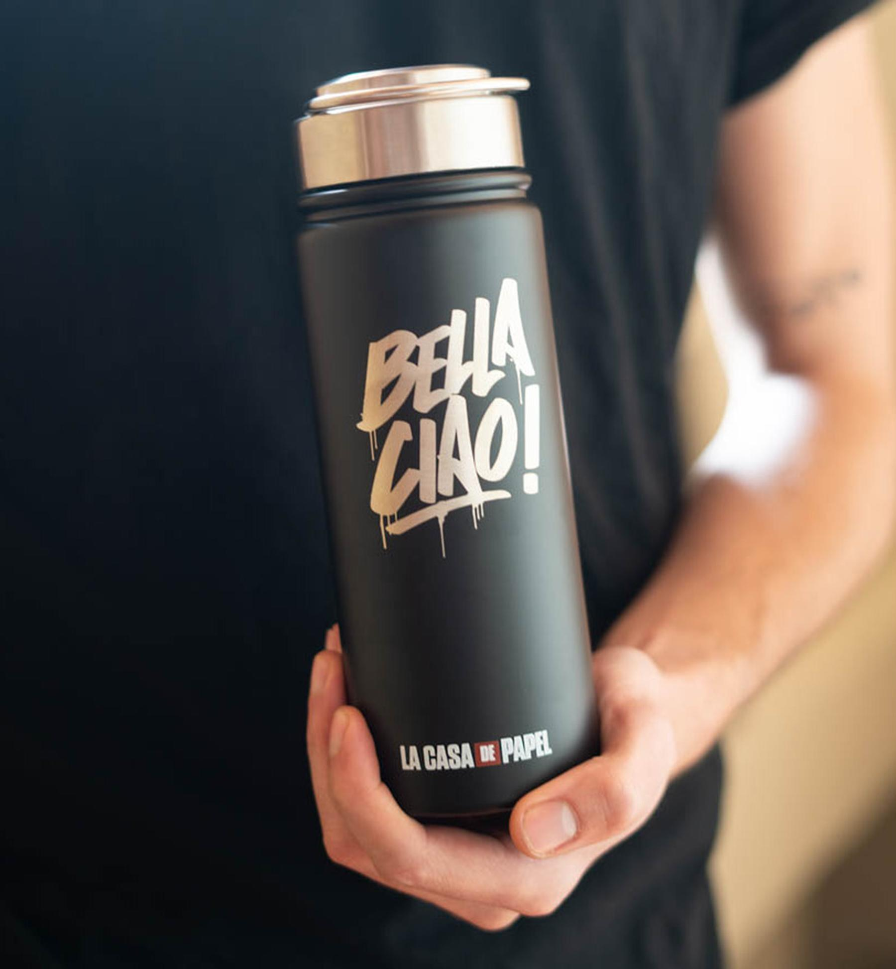 Eine Person hält eine schwarze Wasserflasche mit weißem Text.