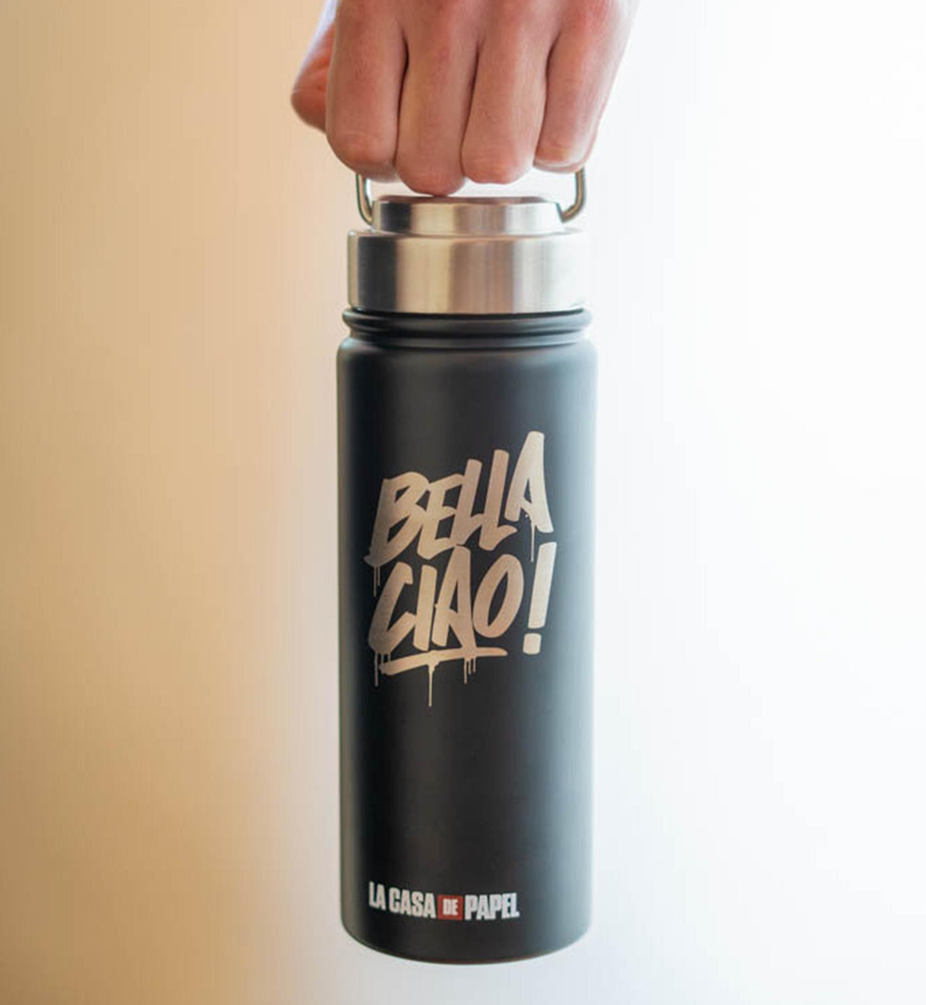 Eine schwarze Wasserflasche mit silbernem 'BELLA CIAO!', die von einer Hand gehalten wird.