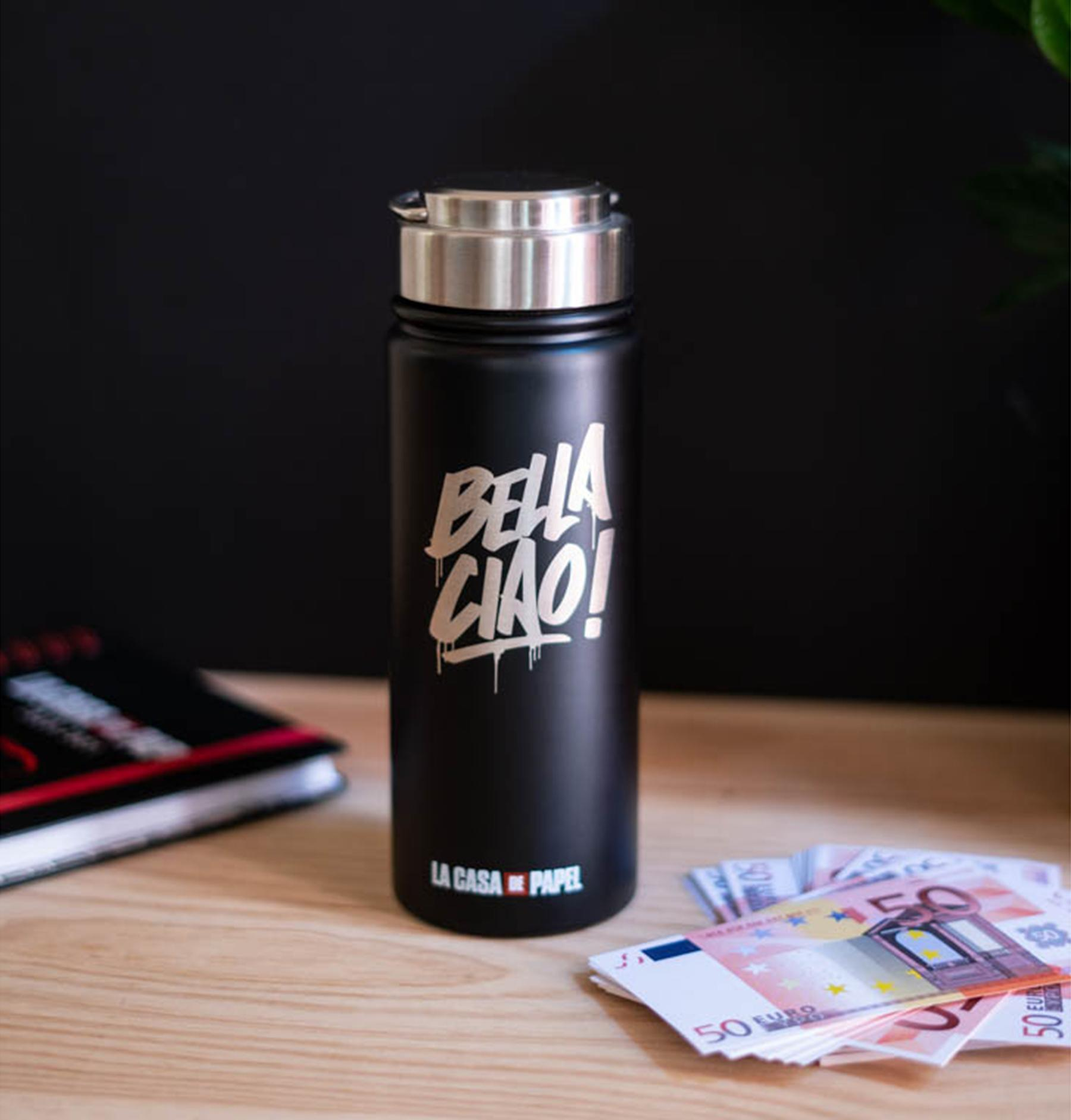 Eine schwarze Wasserflasche mit "BELLA CIAO!" Schriftzug, neben Geld auf einem Holztisch.