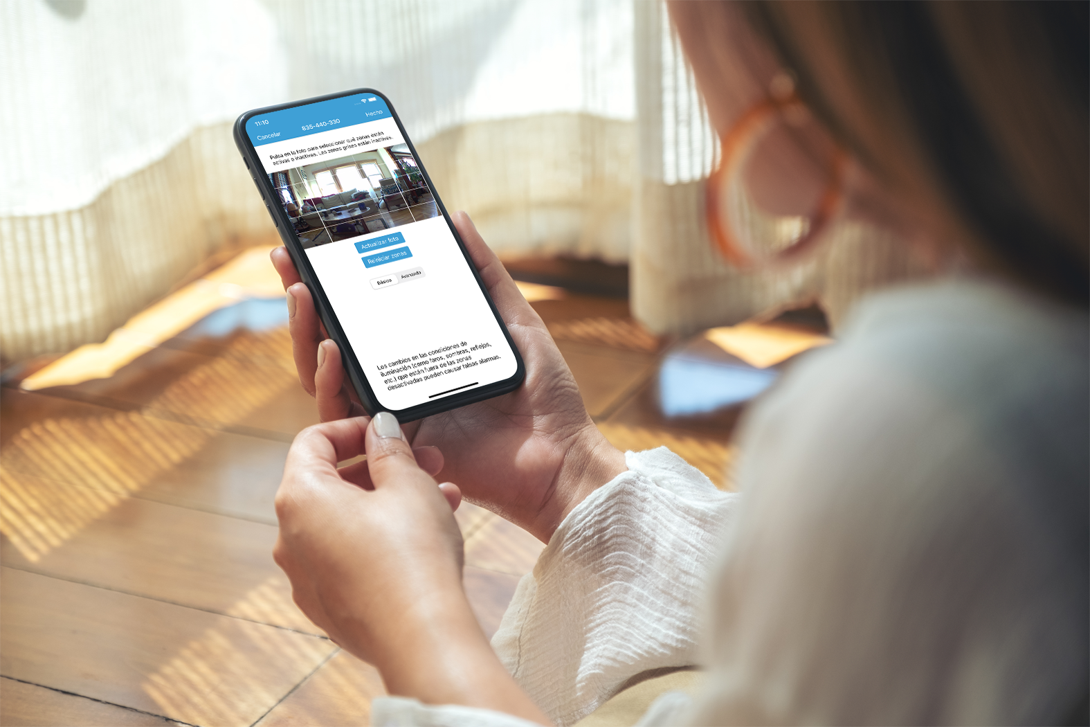 Una persona sosteniendo un smartphone que muestra una interfaz de aplicación con imágenes y texto.