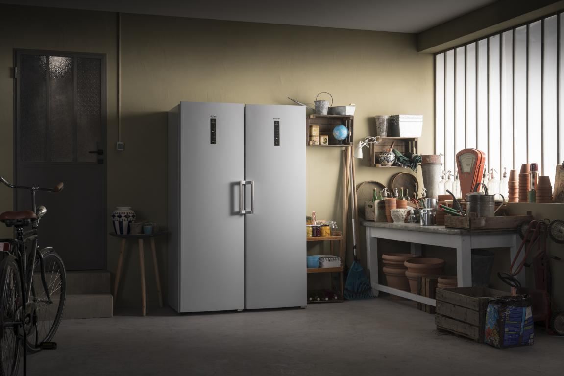 Interior de garaje con dos refrigeradores, una bicicleta y varios artículos de jardinería.