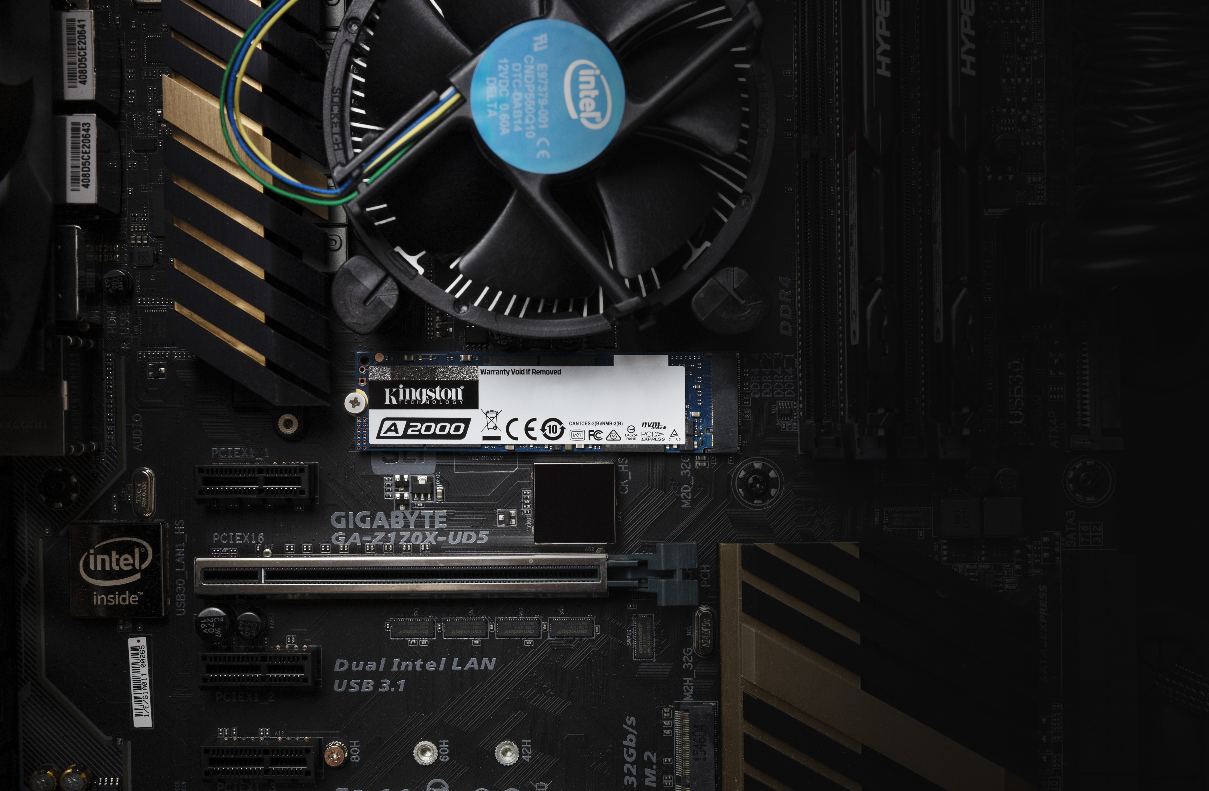 Computer-Mainboard mit CPU-Lüfter und installierter Kingston A2000 SSD. Intel- und Kingston-Logos sichtbar.