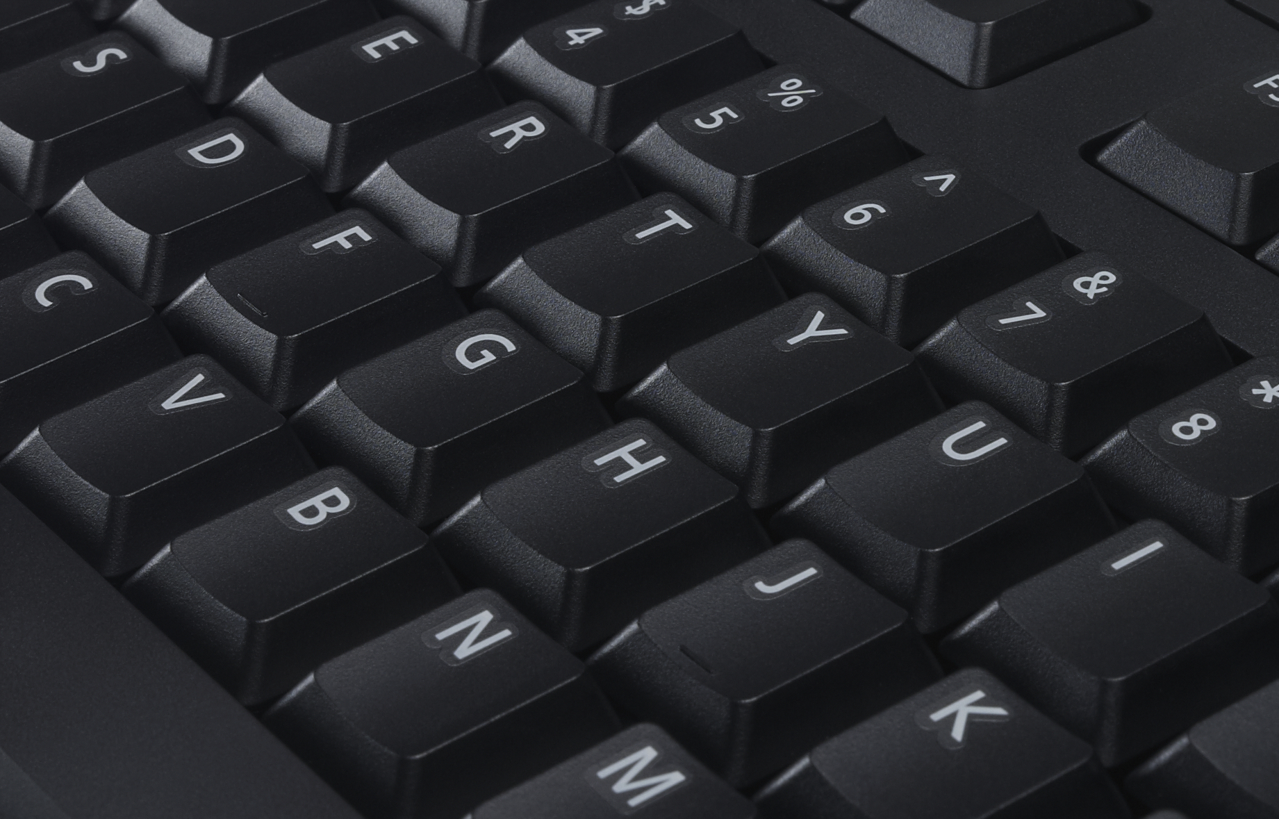 Nahaufnahme einer schwarzen Computertastatur. Die Tasten sind mit weißen Buchstaben und Zahlen beschriftet.
