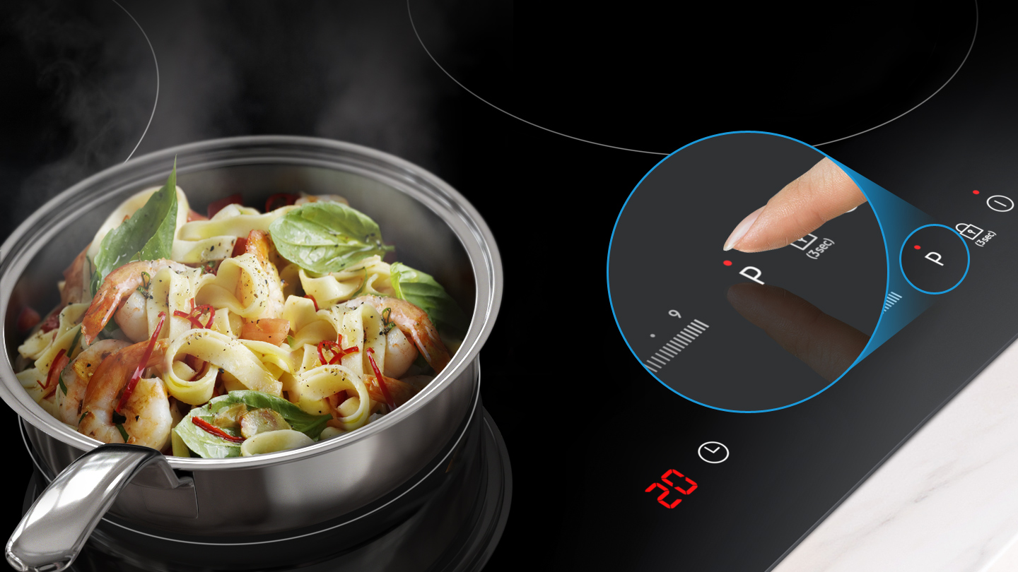 Pot pasta met garnalen op een inductiekookplaat, vinger raakt de aan/uit-knop.