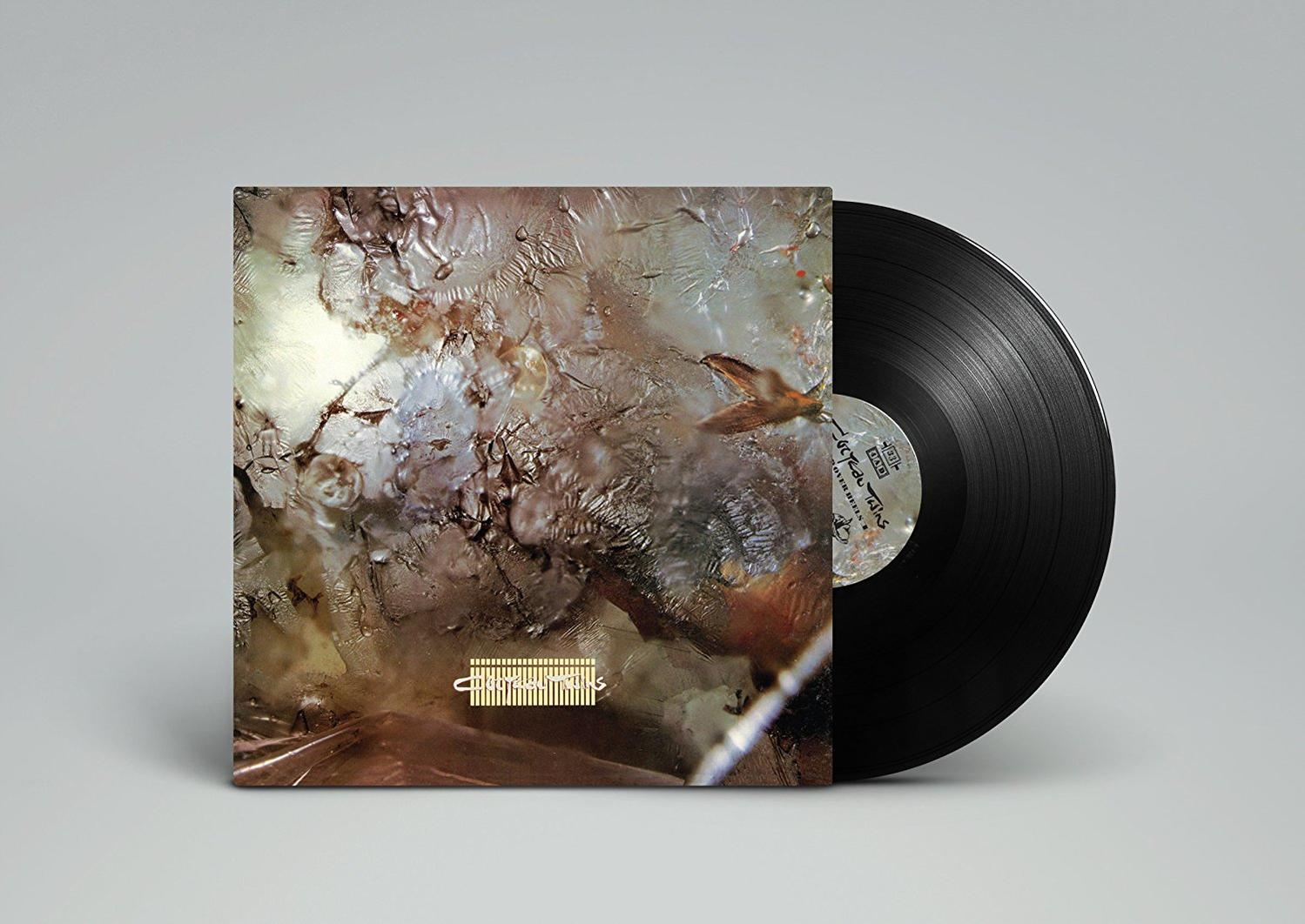 Vinyl-Schallplatte mit farbenfrohem, abstraktem Cover, auf grauem Hintergrund.