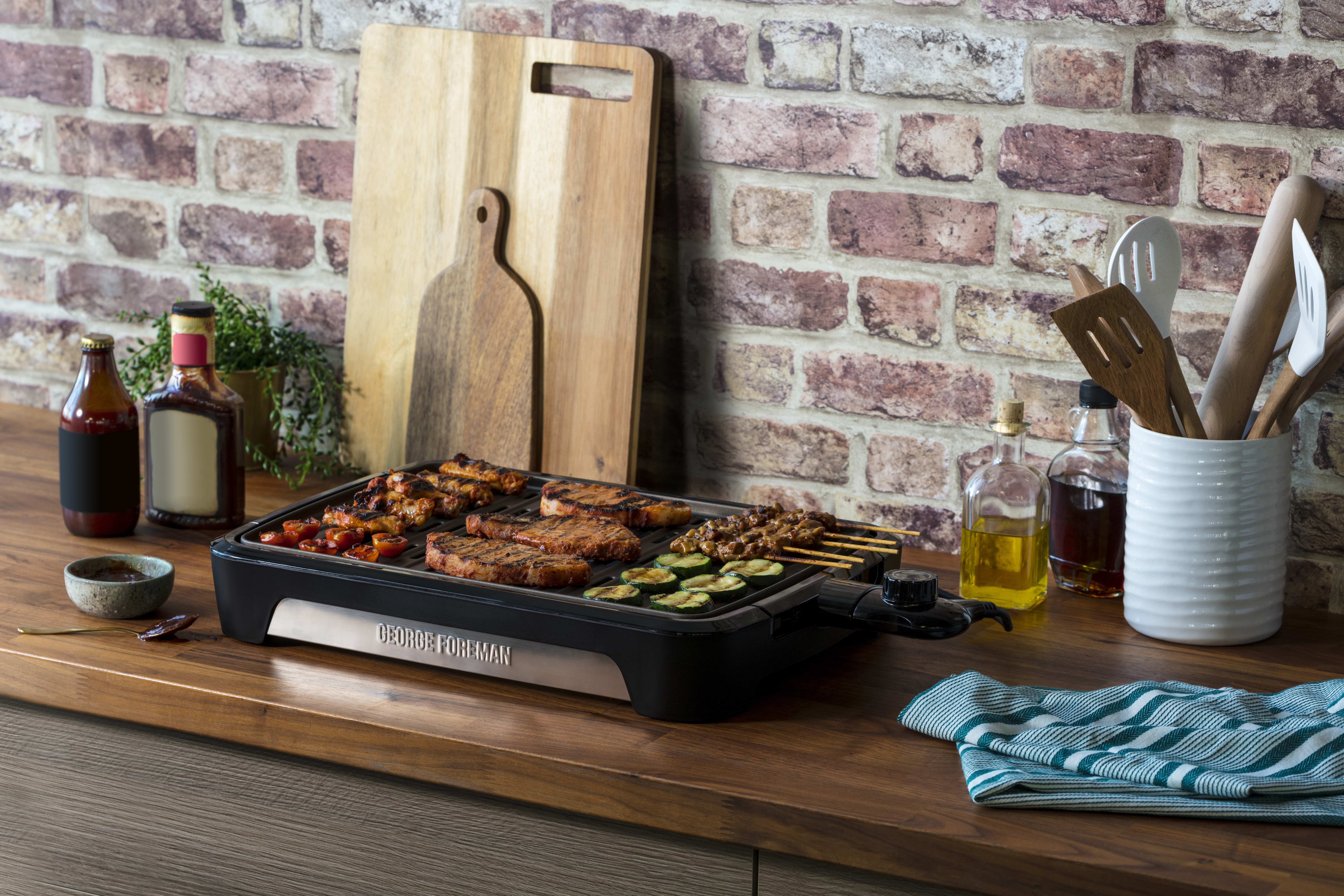 George Foreman grill grillezett ételekkel a konyhapulton, különféle fűszerekkel.