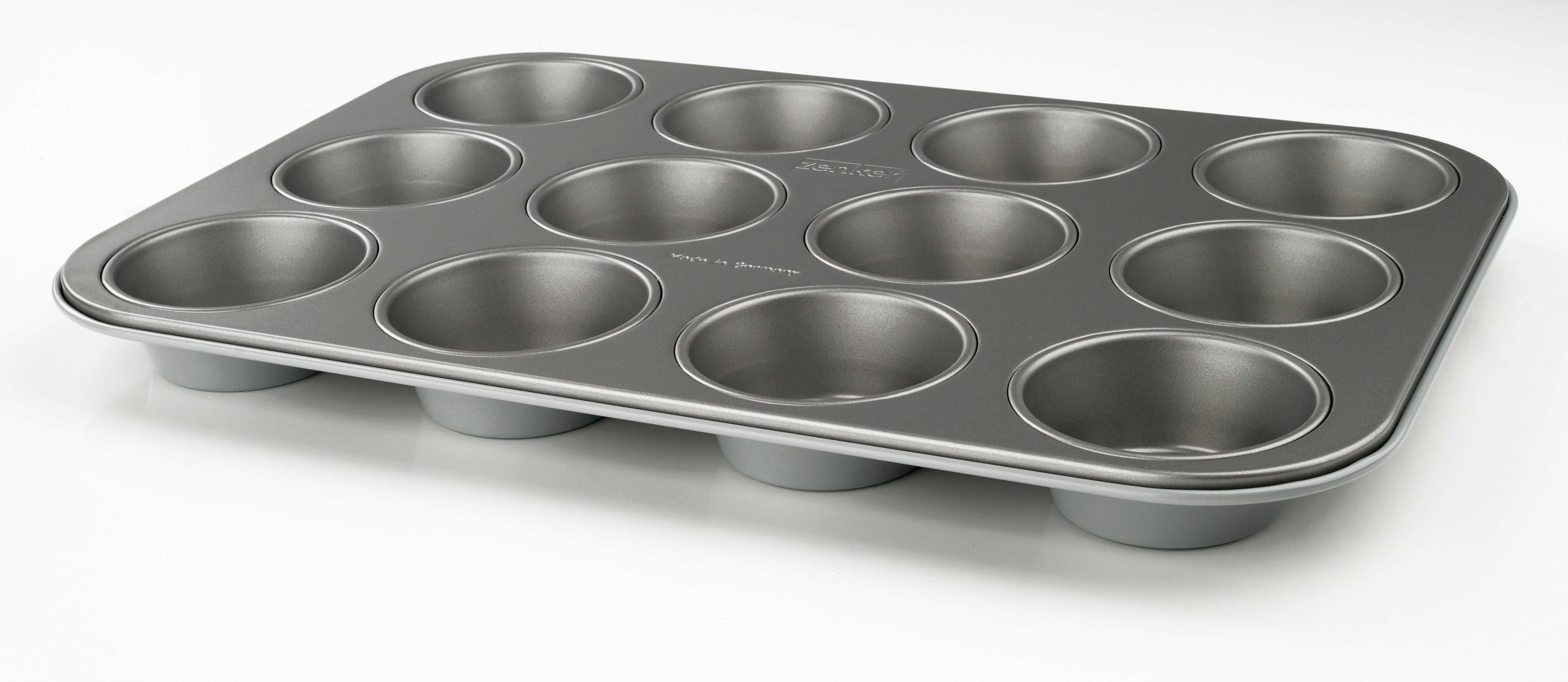 Eine graue Muffinform mit 12 kreisförmigen Formen, auf weißer Oberfläche.