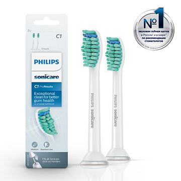 Two white toothbrush heads with green and blue bristles are shown on a white background.
