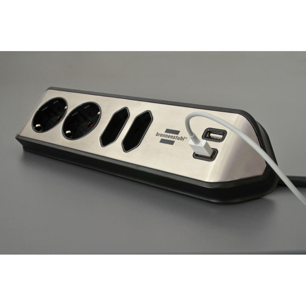 Silber-schwarze Steckdosenleiste mit mehreren Steckdosen und USB-Anschlüssen. Grauer Hintergrund.