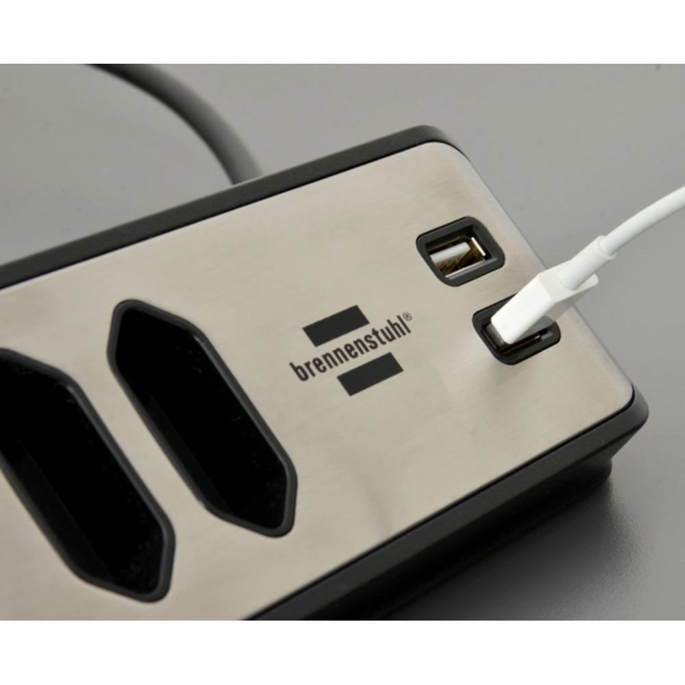 Silberne Steckdosenleiste mit USB-Anschlüssen und einem eingesteckten weißen Kabel. Schwarz-silbernes Design.