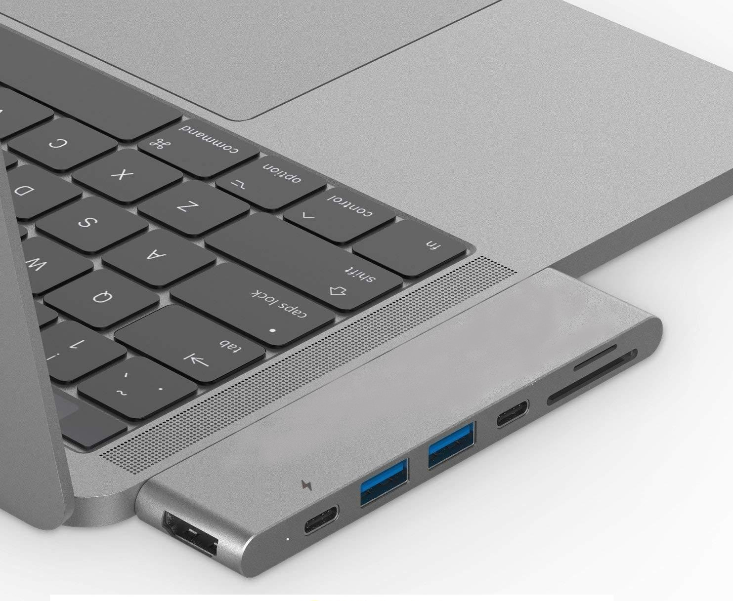 Dizüstü bilgisayara bağlı gümüş USB-C hub, bağlantı noktaları görünür.