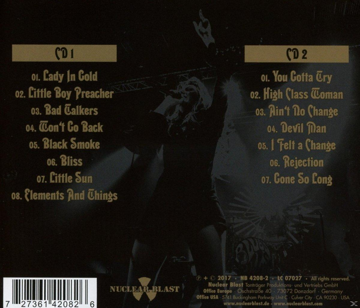 CD-borító számlistákkal és egy előadó sziluettjével a színpadon.