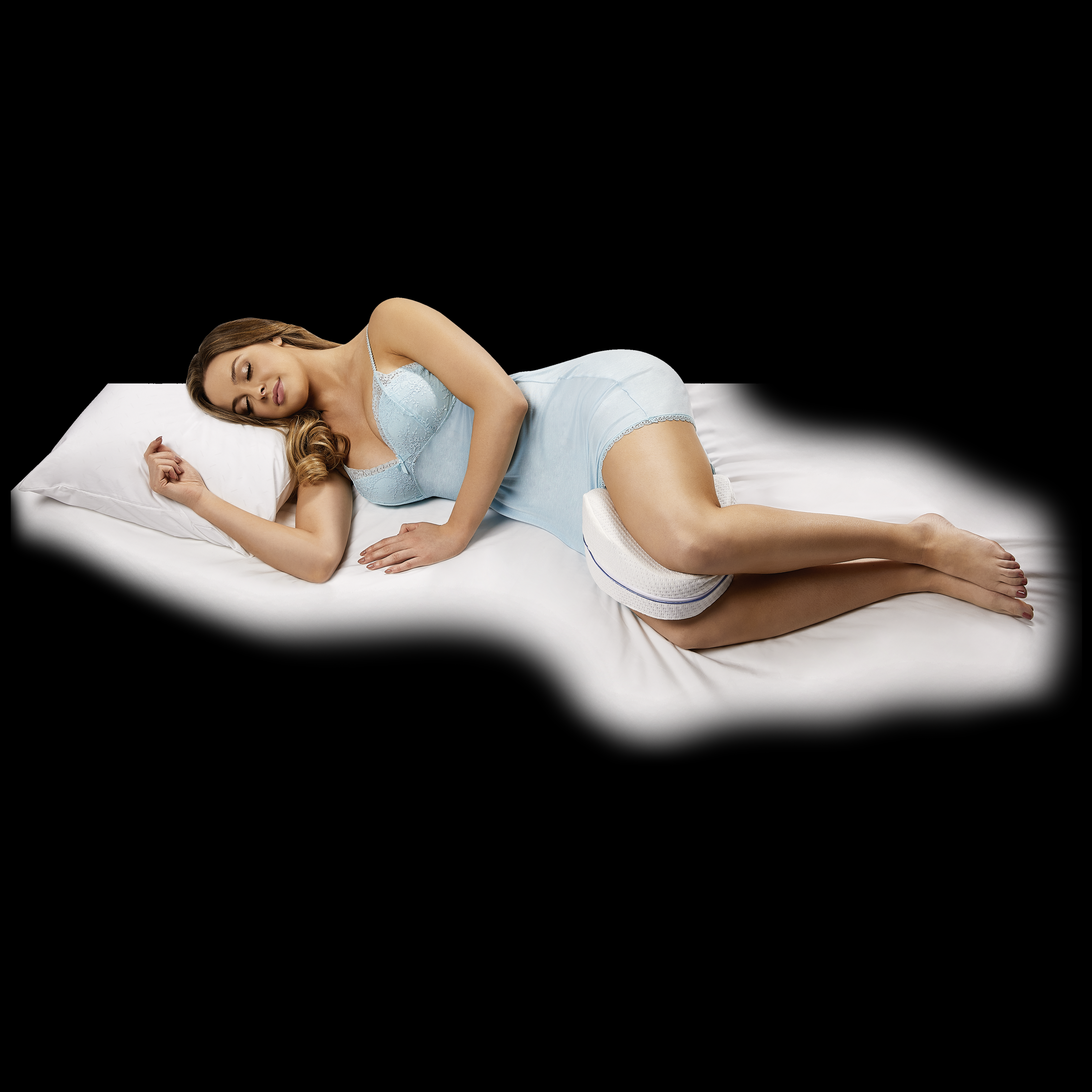 Frau in blauer Nachtwäsche liegt auf einem Bett mit einem Kissen, ein Bein-Kissen ist zwischen ihren Beinen.