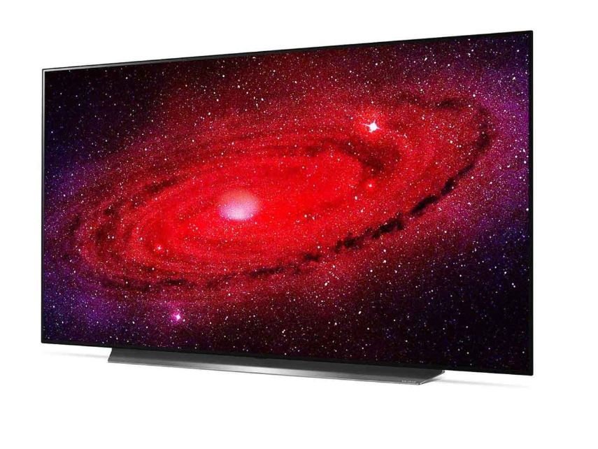 Düz ekran bir TV, kırmızı ve mor bir galaksiyi görüntülüyor. Yıldızlar ve renk girdapları kozmik bir sahne yaratıyor. TV'nin siyah bir çerçevesi var.