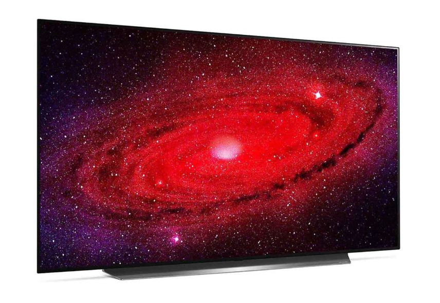 Düz ekran bir TV, kırmızı ve mor bir galaksi görüntüsü gösteriyor. TV'nin ince, siyah bir çerçevesi ve gümüş bir standı var.