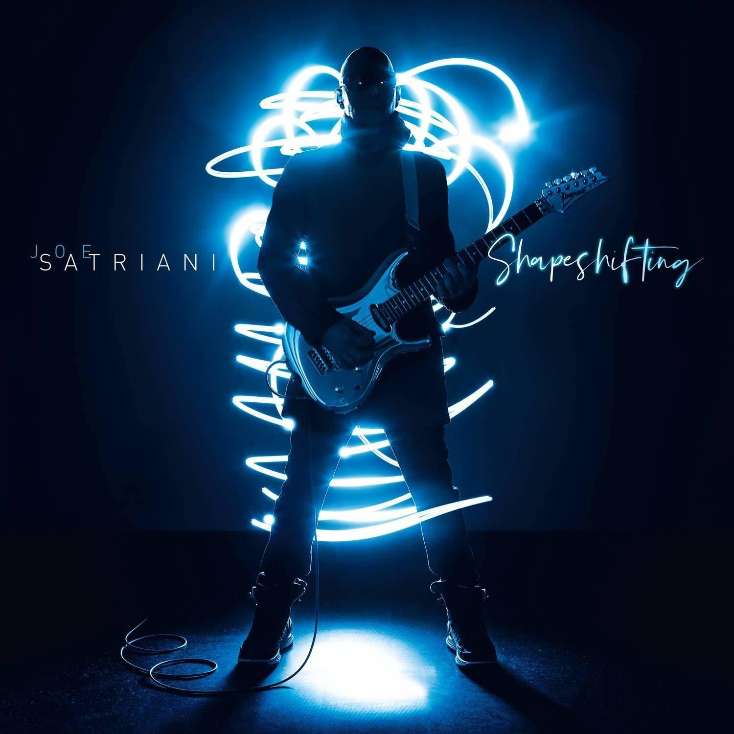 Man die gitaar speelt met neonlichtkunst om hem heen. Het woord 'Shapeshifting' is zichtbaar.