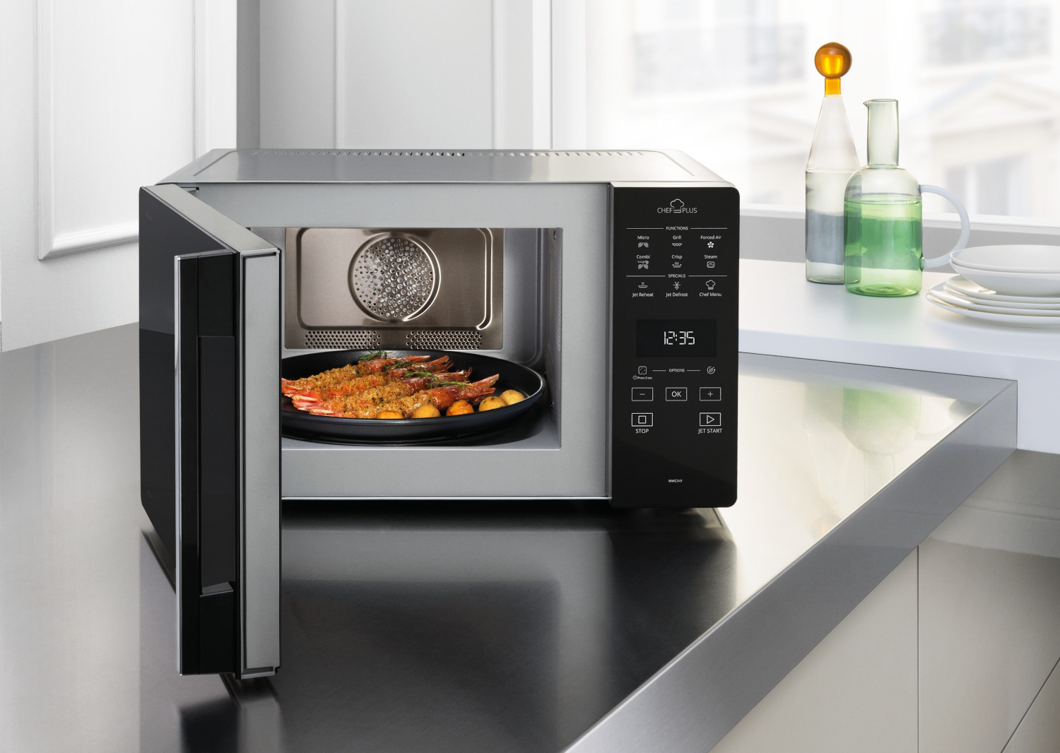 Un four à micro-ondes avec la porte ouverte. Une assiette de nourriture est à l'intérieur et le panneau de contrôle est visible.
