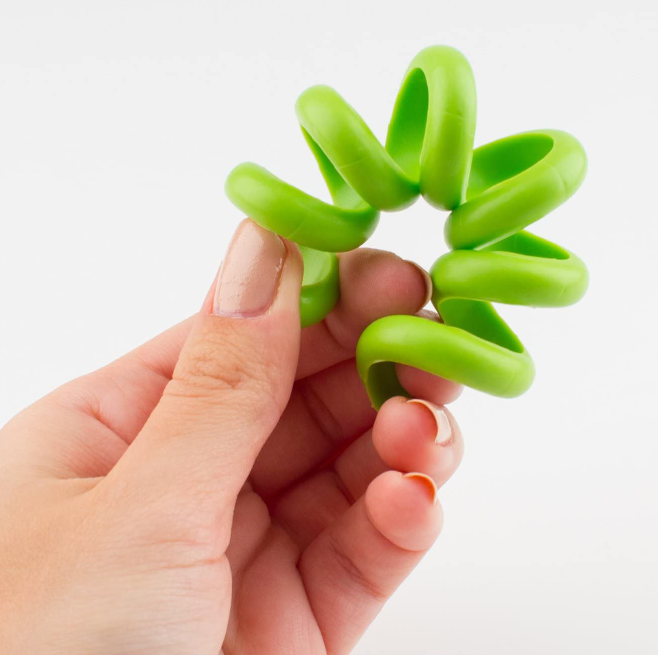 Main tenant un jouet vert en forme de spirale.