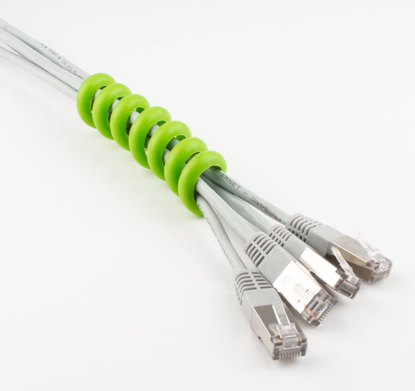 Câbles réseau gris maintenus ensemble par un organiseur de câbles en spirale vert.